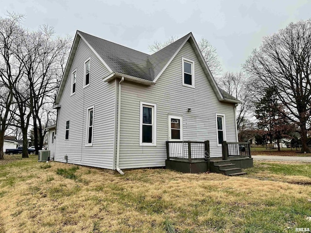 rear view of house with a deck, central AC unit, and a lawn