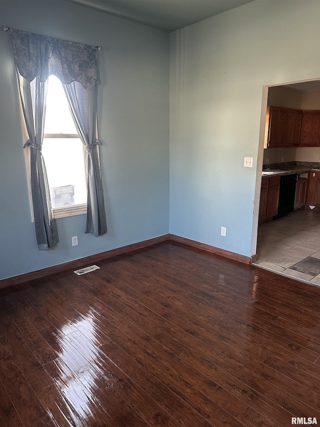 spare room featuring visible vents, baseboards, and hardwood / wood-style floors