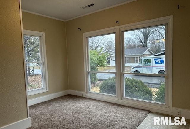 entryway with carpet, a healthy amount of sunlight, and ornamental molding