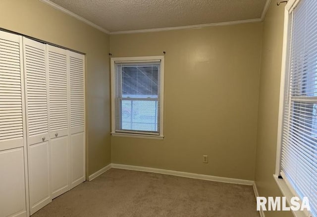 unfurnished bedroom featuring a closet, light colored carpet, a textured ceiling, and ornamental molding