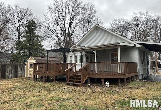 rear view of house featuring a storage shed and a wooden deck