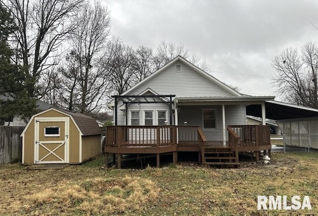 rear view of house with a carport and a storage unit