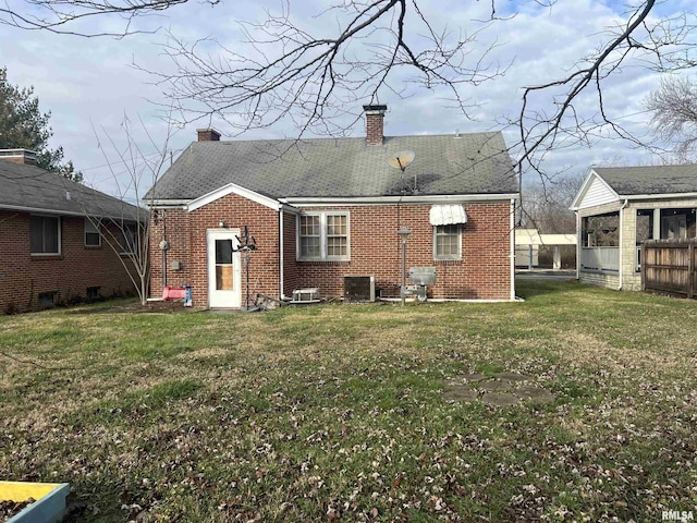 back of house featuring a lawn and central AC