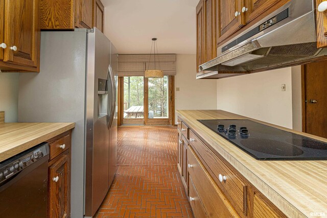 kitchen featuring wooden counters, decorative light fixtures, and black appliances