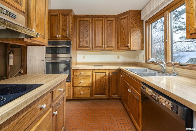 kitchen featuring black appliances, butcher block countertops, sink, and exhaust hood