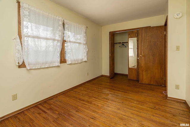 unfurnished bedroom featuring hardwood / wood-style floors and a closet