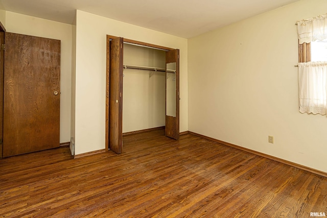 unfurnished bedroom featuring a closet and dark wood-type flooring