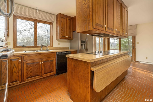 kitchen with black appliances, a center island, sink, and a wealth of natural light