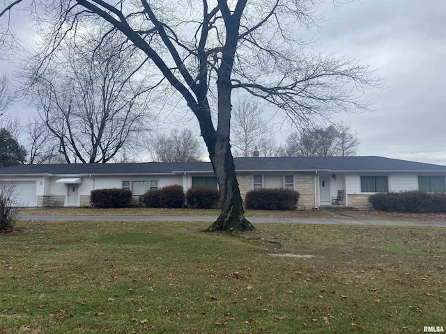 single story home featuring a front lawn and a garage