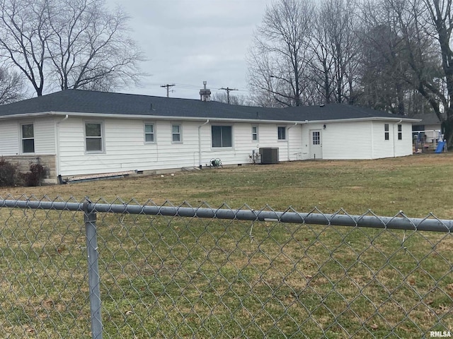 back of property with central air condition unit and a yard