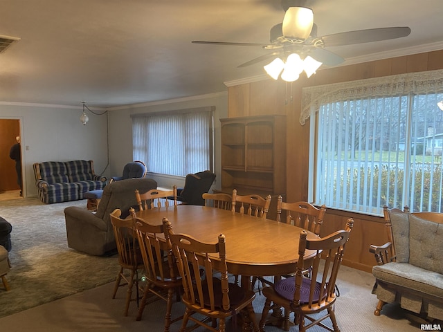 carpeted dining area featuring ceiling fan and ornamental molding