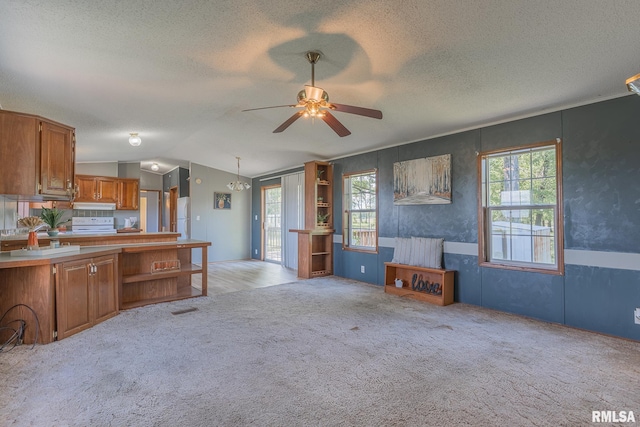 408 W Kirkwood St, Odin, IL 62870 - kitchen featuring a textured ceiling, ceiling fan, light colored carpet, brown cabinetry, and open floor plan