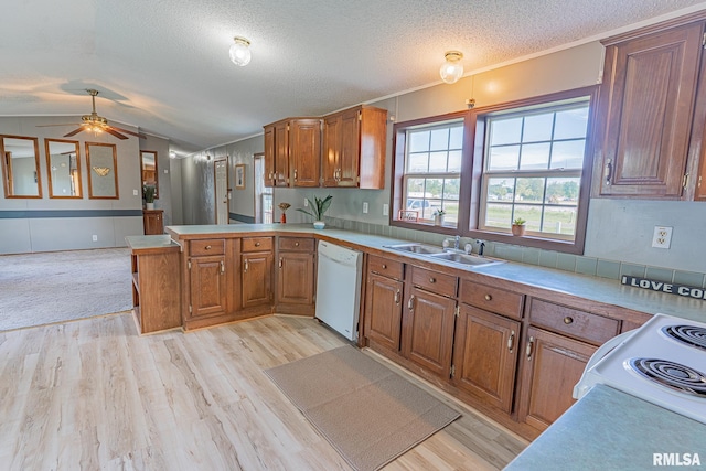 408 W Kirkwood St, Odin, IL 62870 - kitchen with white dishwasher, brown cabinetry, a peninsula, vaulted ceiling, and light wood-type flooring