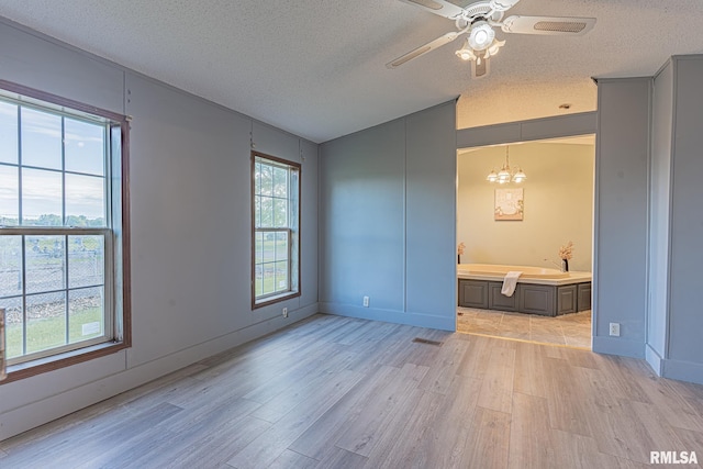 408 W Kirkwood St, Odin, IL 62870 - unfurnished room with light wood-type flooring, a textured ceiling, ceiling fan, a chandelier, and baseboards