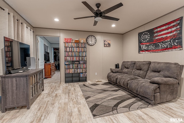 living room with ceiling fan, ornamental molding, and light hardwood / wood-style flooring