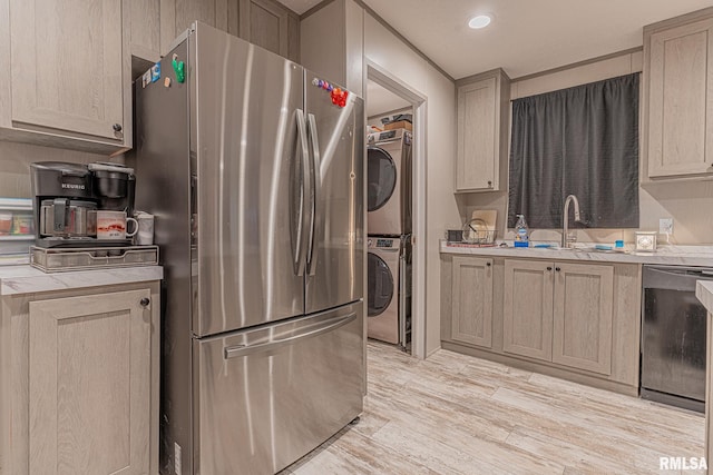 kitchen featuring stainless steel fridge, stacked washing maching and dryer, black dishwasher, and light brown cabinets