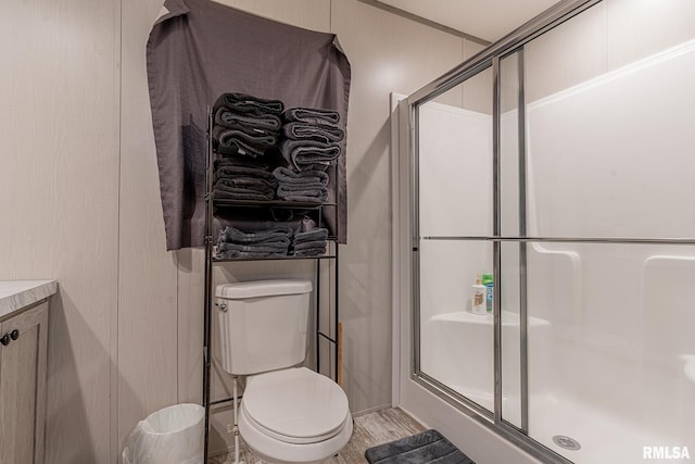 bathroom featuring vanity, an enclosed shower, and toilet