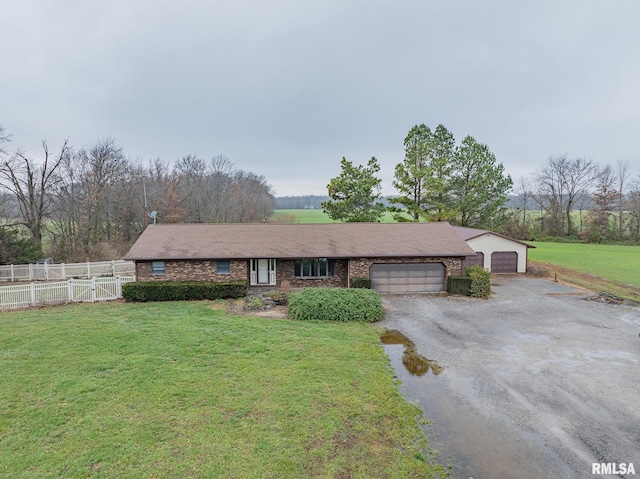 single story home featuring a front lawn and a garage