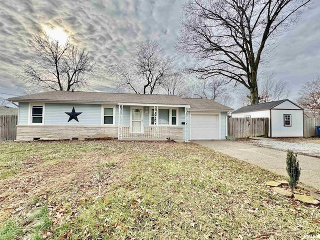 ranch-style home featuring a porch, a front lawn, a shed, and a garage