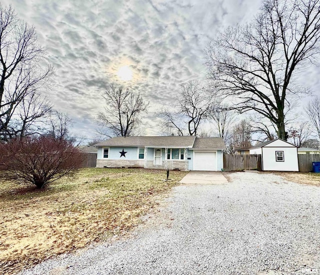 single story home featuring a front lawn, a shed, and a garage