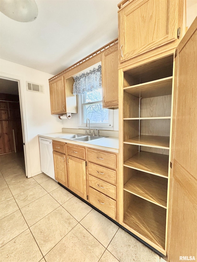 kitchen with white dishwasher, light tile patterned flooring, sink, and light brown cabinetry