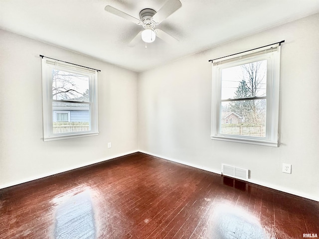 unfurnished room with ceiling fan and dark wood-type flooring