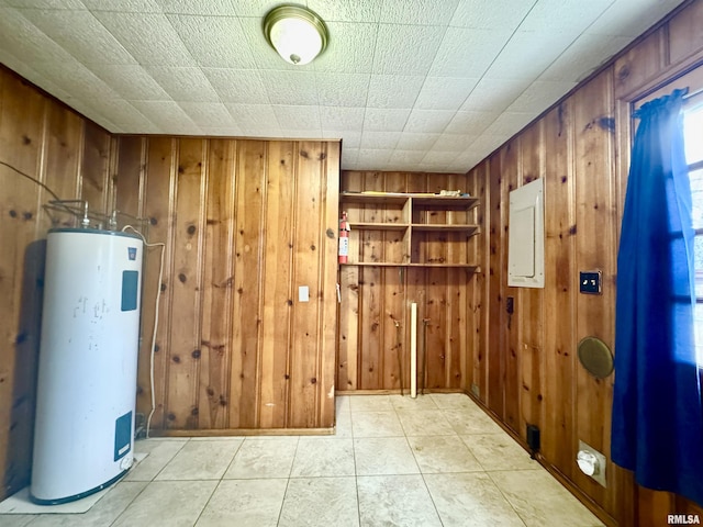 interior space with wood walls, electric water heater, and electric panel