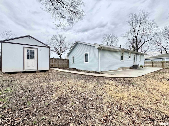 back of house featuring a patio area, cooling unit, and a storage shed