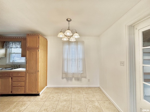 unfurnished dining area with sink, light tile patterned floors, and an inviting chandelier