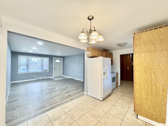 kitchen with a notable chandelier, white appliances, and light tile patterned floors