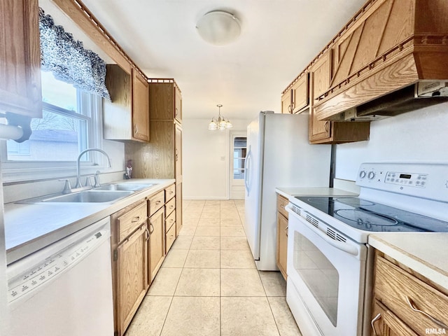 kitchen featuring sink, a chandelier, decorative light fixtures, white appliances, and light tile patterned flooring