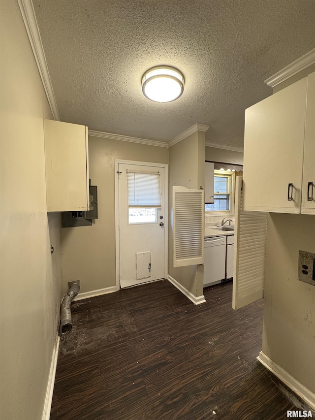 clothes washing area with cabinets, dark hardwood / wood-style flooring, crown molding, and a textured ceiling