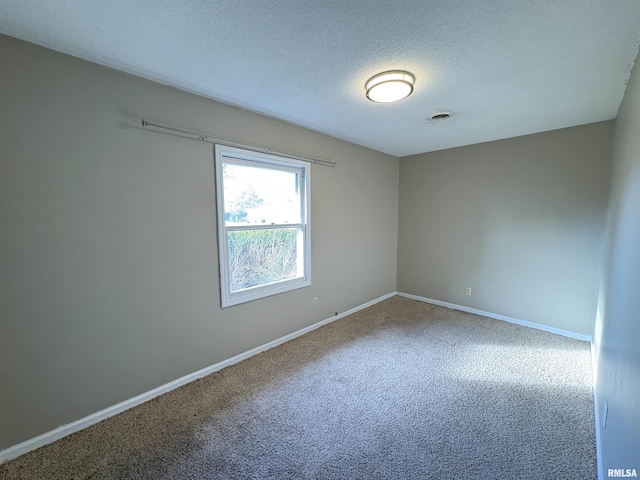 carpeted spare room featuring a textured ceiling