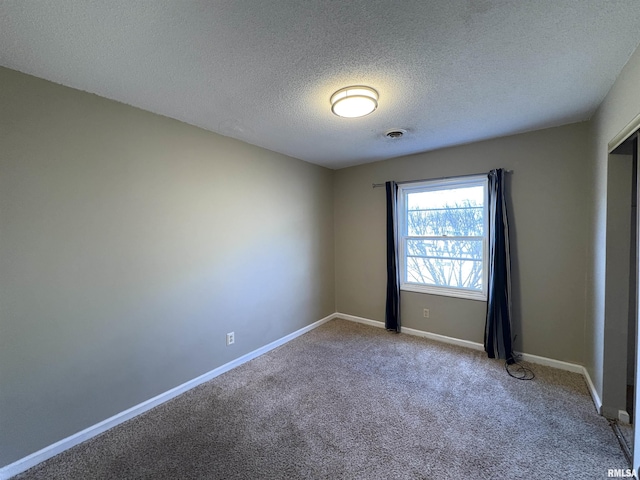 empty room featuring carpet flooring and a textured ceiling