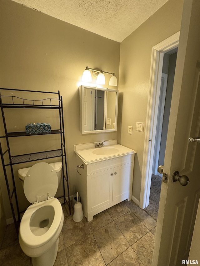 bathroom featuring vanity, toilet, and a textured ceiling