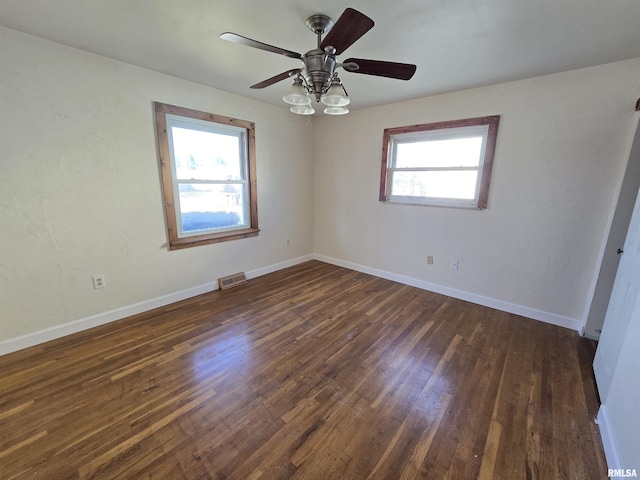 spare room with dark hardwood / wood-style floors and ceiling fan