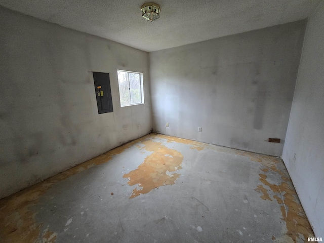 unfurnished room featuring a textured ceiling and electric panel