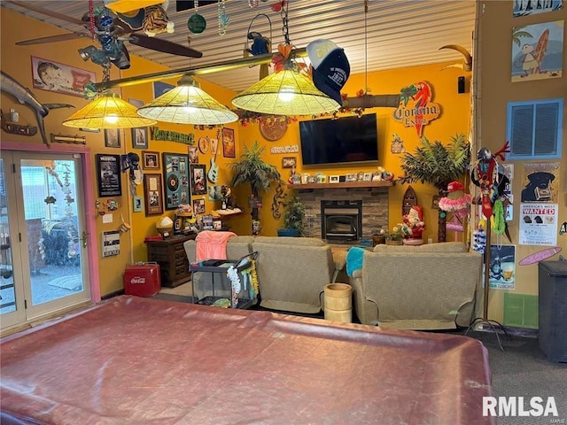 living room featuring carpet flooring, a wood stove, and billiards