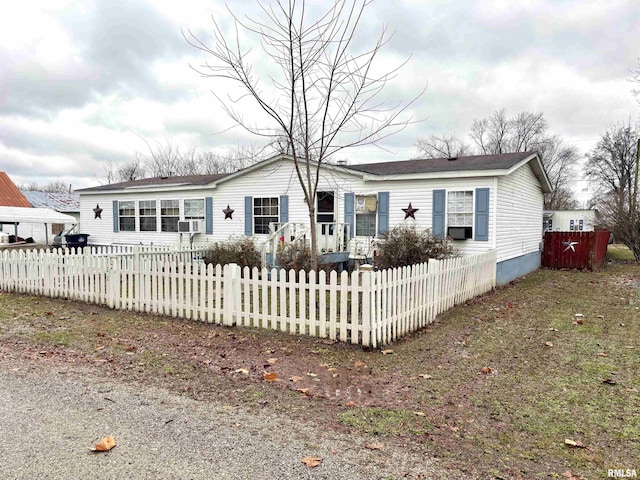 manufactured / mobile home featuring a fenced front yard and cooling unit