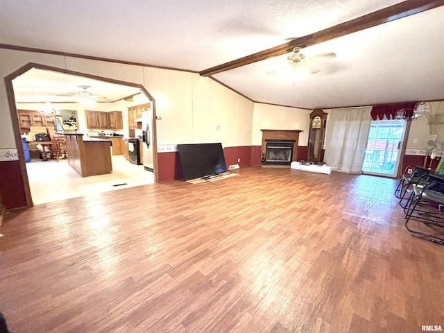 living room featuring ceiling fan, lofted ceiling with beams, crown molding, hardwood / wood-style floors, and a textured ceiling