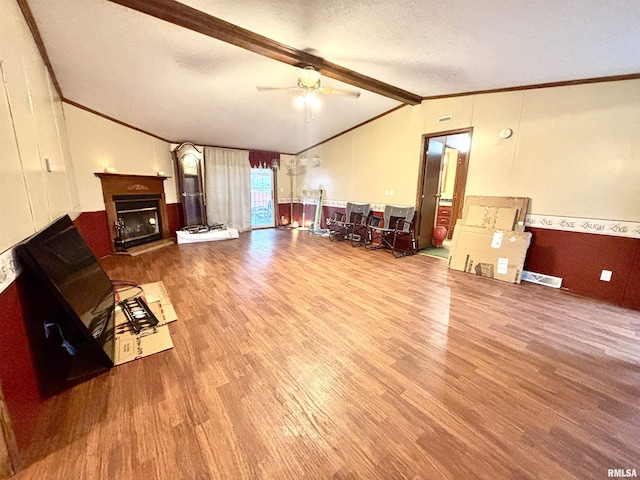 living room featuring ceiling fan, vaulted ceiling with beams, crown molding, hardwood / wood-style floors, and a textured ceiling