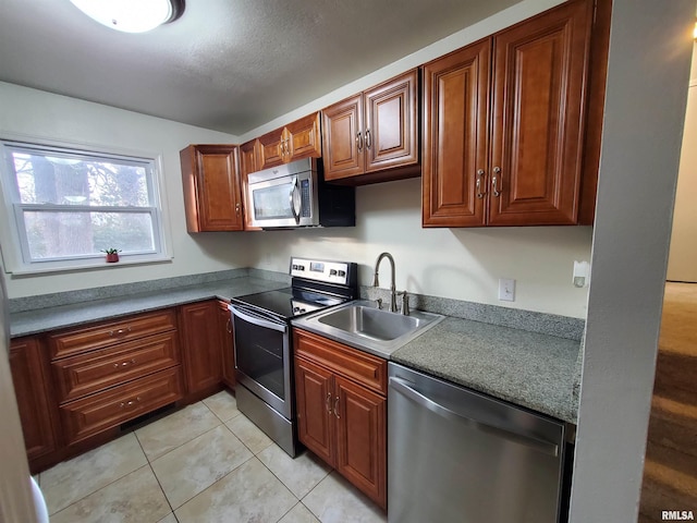 kitchen with light tile patterned flooring, stainless steel appliances, and sink