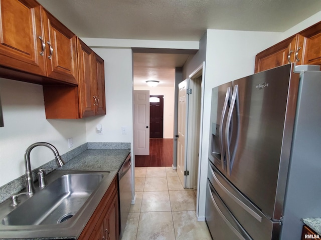 kitchen featuring sink, light tile patterned floors, and appliances with stainless steel finishes