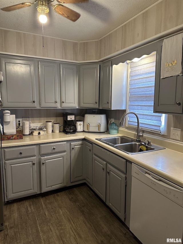 kitchen with sink, white dishwasher, dark hardwood / wood-style floors, and a textured ceiling