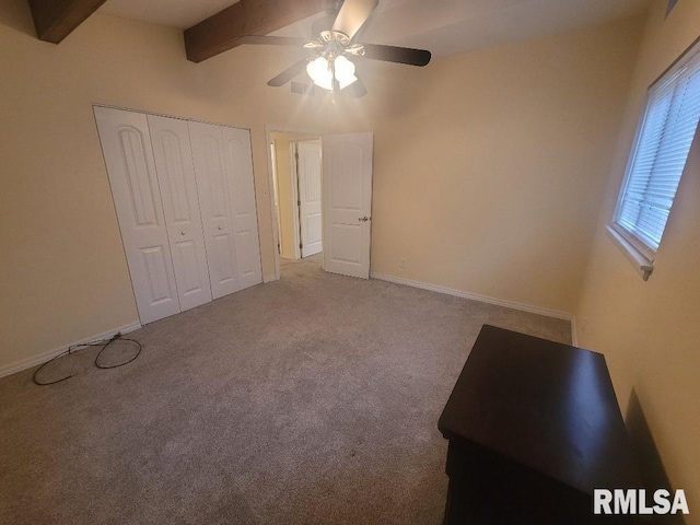 unfurnished bedroom featuring lofted ceiling with beams, carpet floors, a closet, and ceiling fan