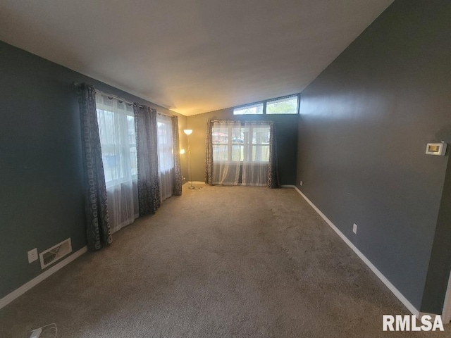 unfurnished room featuring carpet flooring and vaulted ceiling