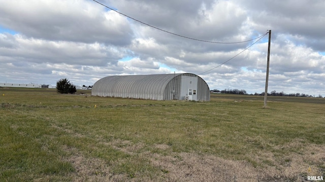 view of outbuilding featuring a rural view and a yard