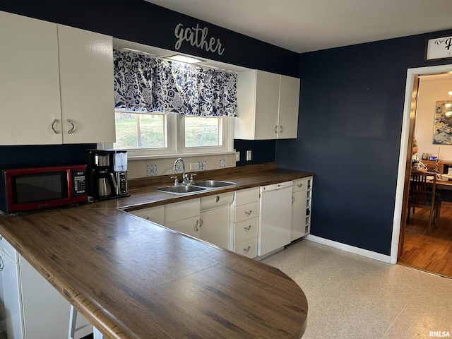 kitchen with white cabinets, sink, white dishwasher, and wood counters