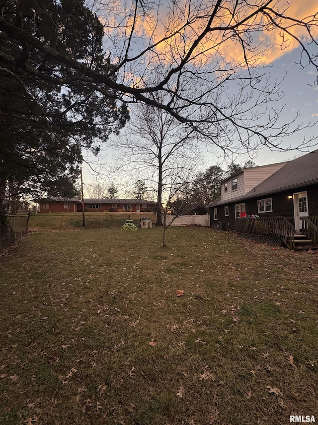 yard at dusk featuring a deck