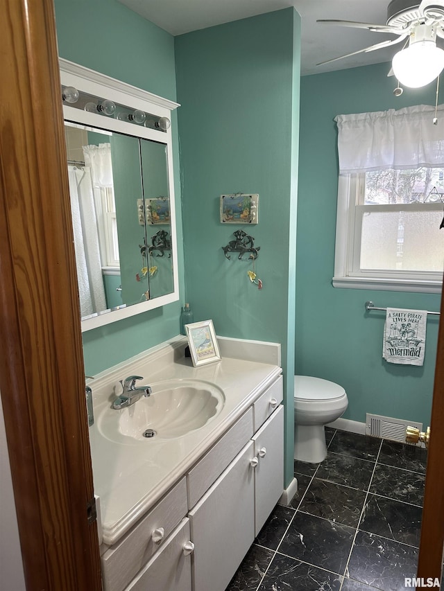 bathroom featuring vanity, ceiling fan, and toilet